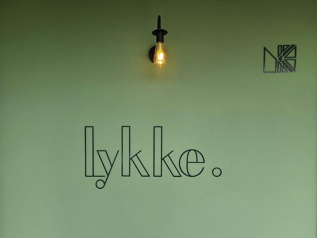 Wall with the logos of Lykke Architecture Studio showing its artistic design.